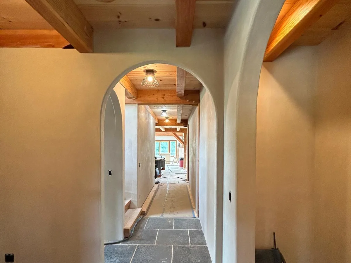 Hallway finished in American Clay with arched openings over a slate floor