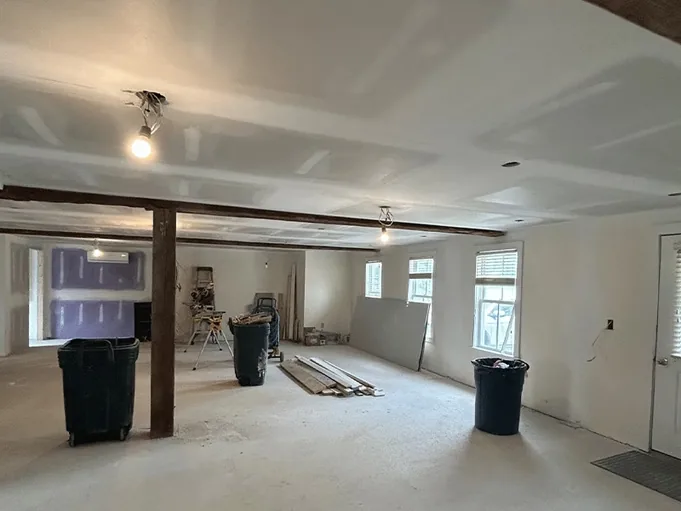 Wide open plan interior with drywall hung and taped around a structural post