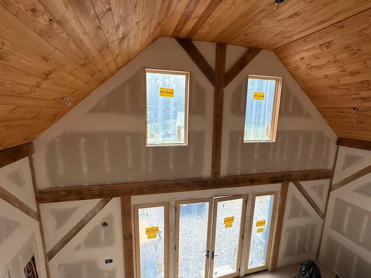Drywall taped around a timber frame gable wall with french doors below