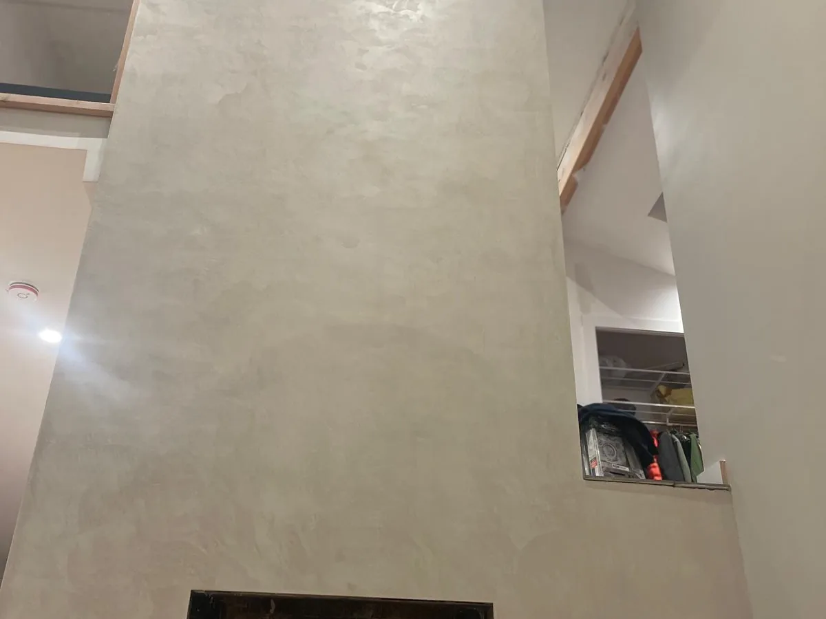 Cream polished plaster fireplace column rising through a double height great room