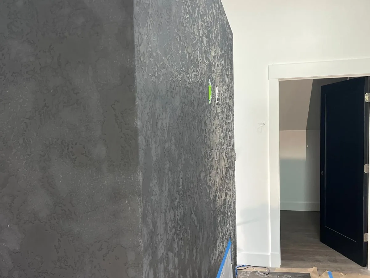 Dark plaster chimney breast seen from the corner of a finished room